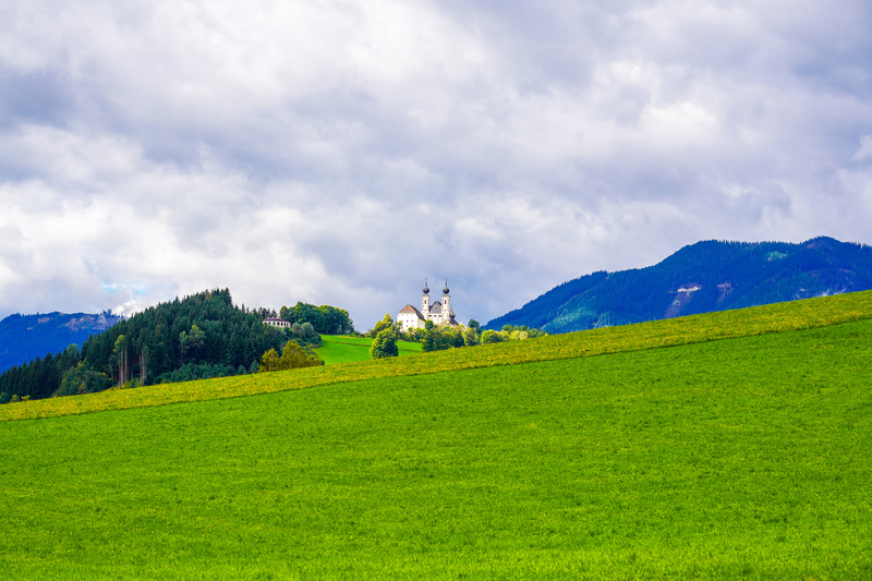 View of the Frauenberg pilgrimage church on the Enns and the surrounding landscape. Historic Christian church in the Ennstal in the town of Frauenberg.