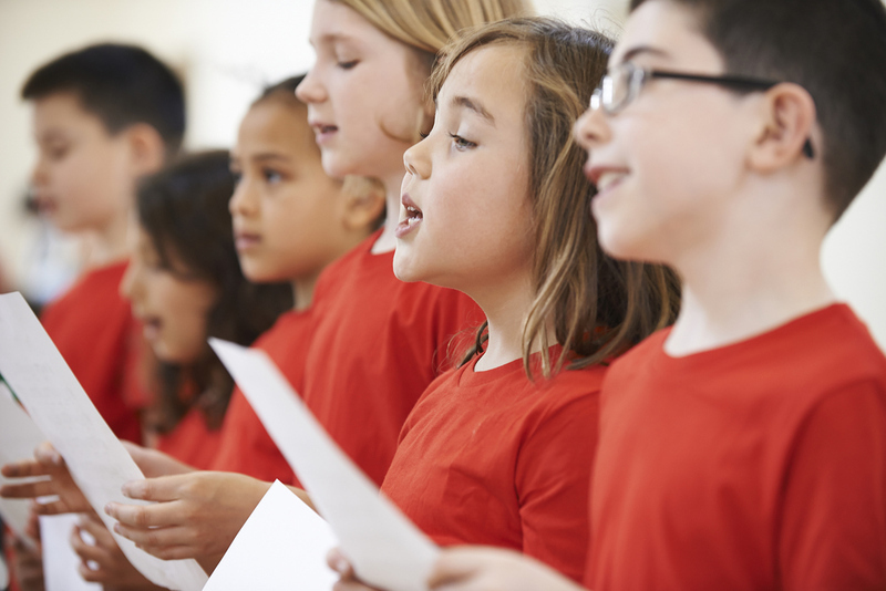 Group Of School Children Singing In Choir Together