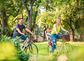 Happy family. Happy active father and mother with kid on bicycles having fun in parkHappy active father and mother with kid on bicycles having fun in park.