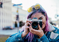 Close-up image of urban female photographer using camera.